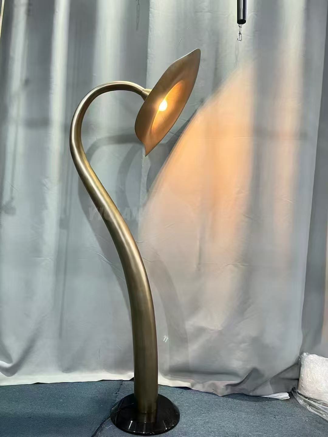 Curved brass floor lamp during workshop testing