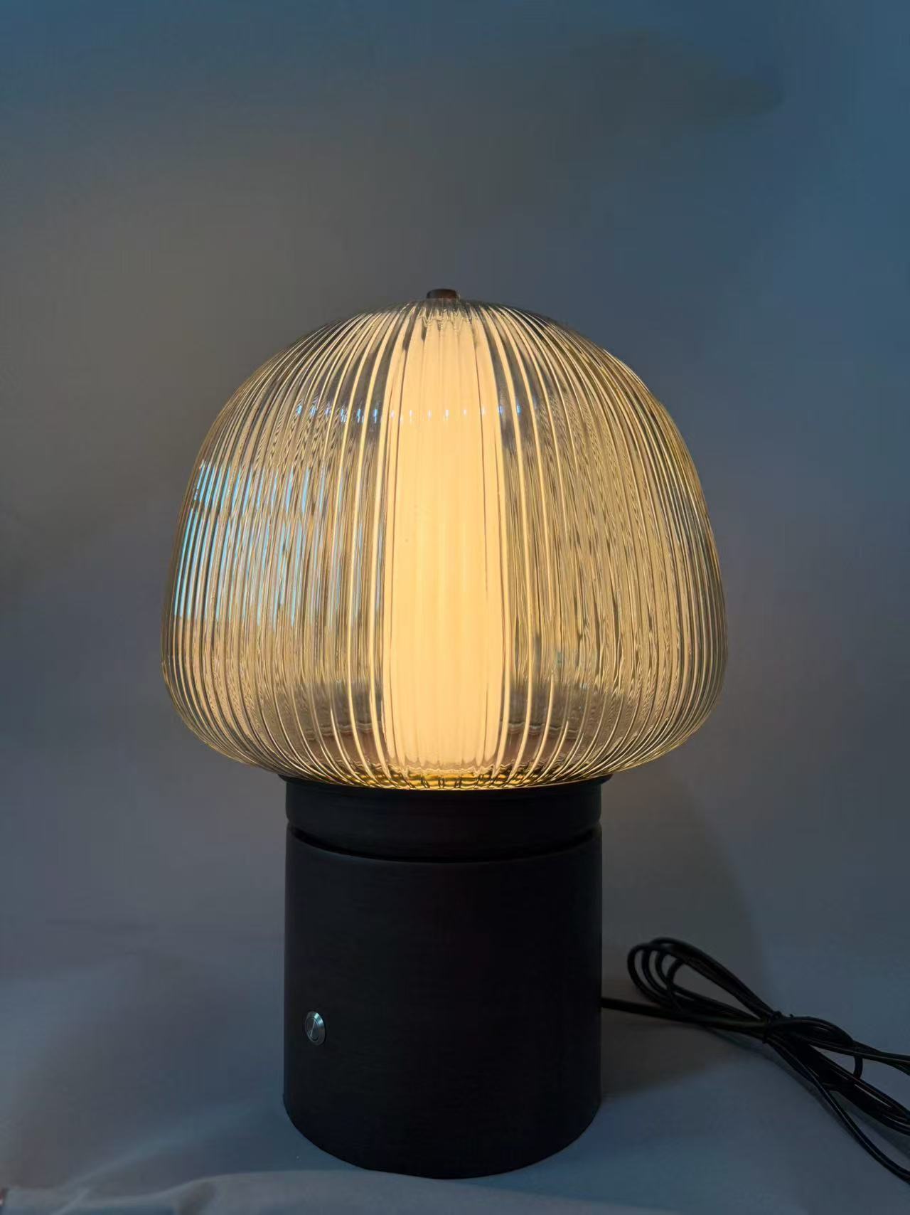 Compact light with a ribbed glass dome and dark cylindrical base in the workshop