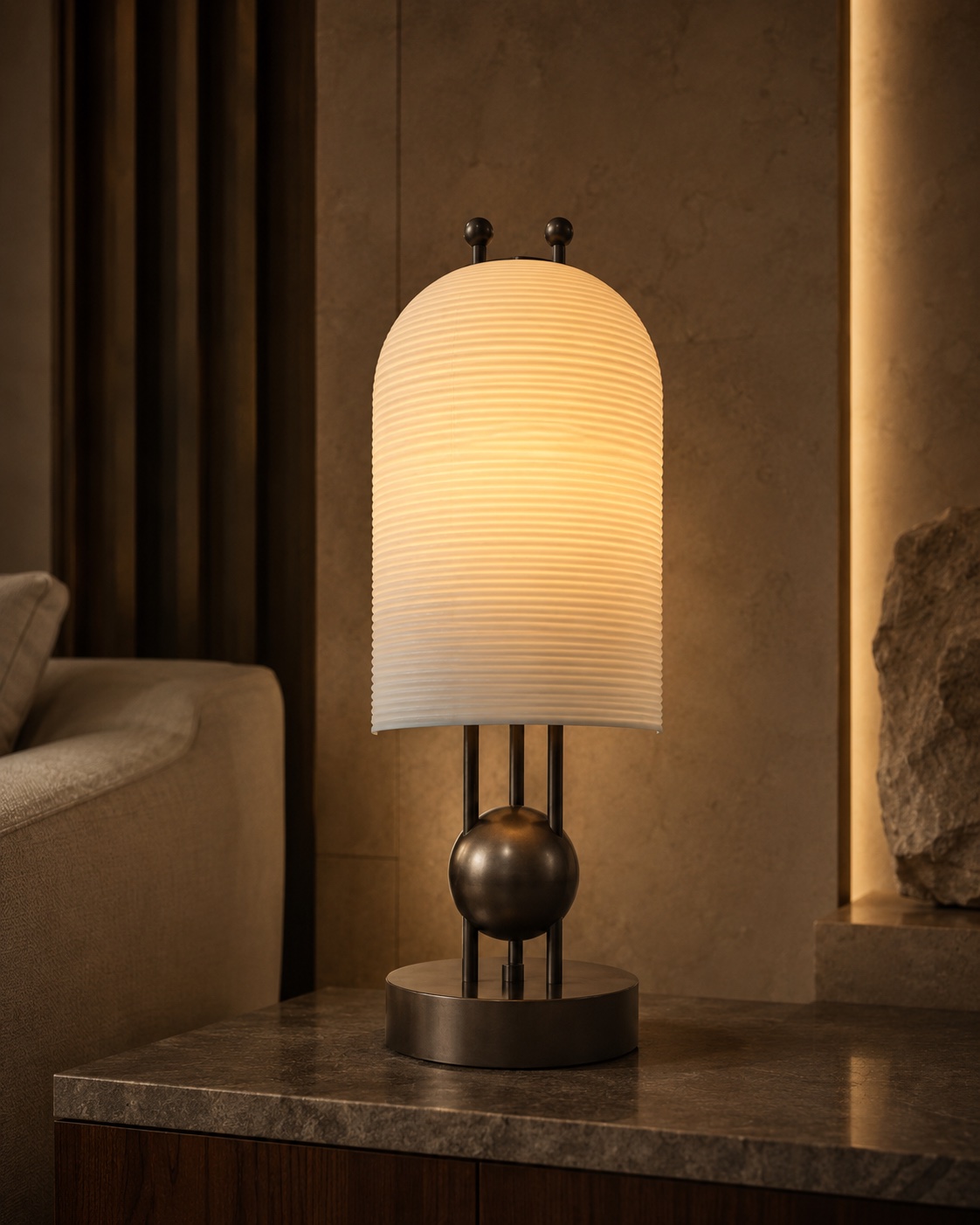 Table lamp with a softly illuminated textured shade, metal sphere detail and round base