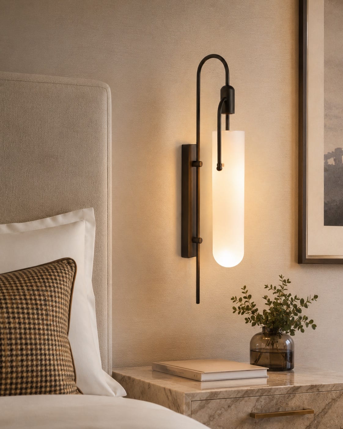 Custom opal glass bedside wall light with an extended bronze frame beside a hotel headboard